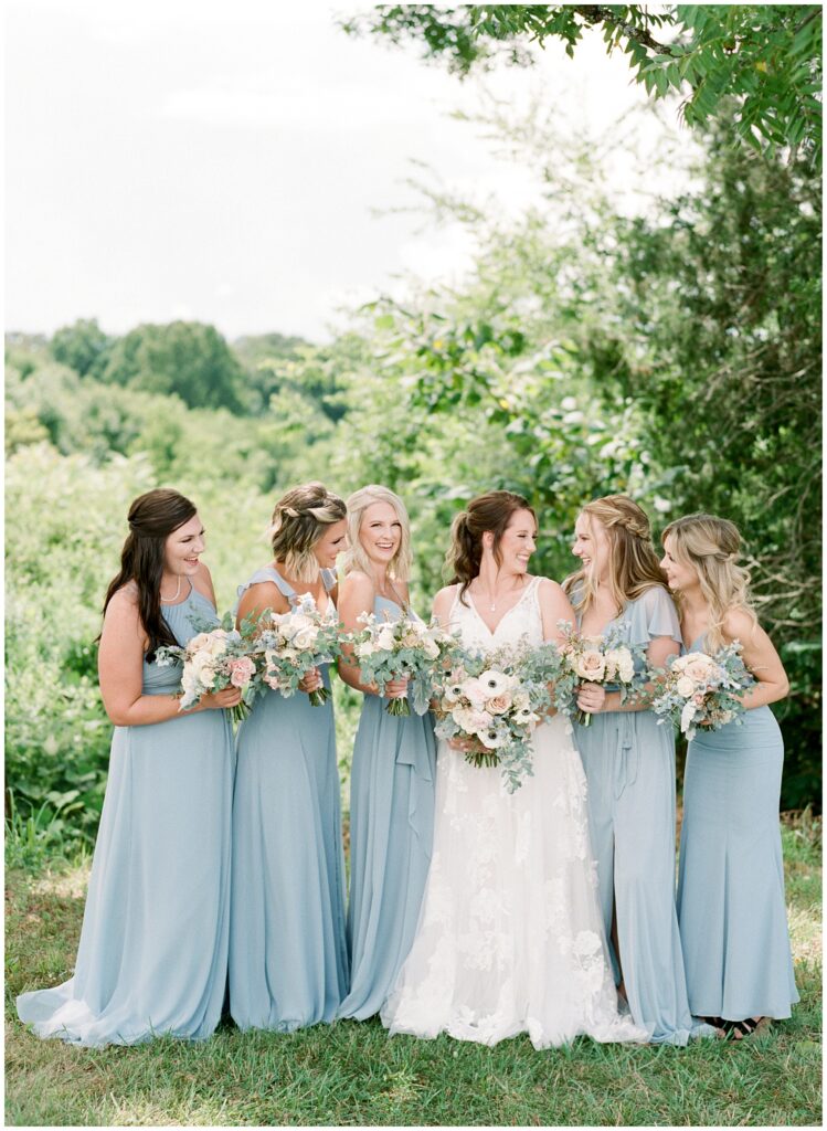 bride and bridesmaids with bouquets laughing
