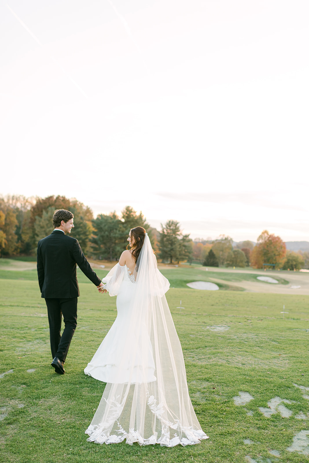 Bride and Groom walking on the golf course at the Virginian at sunset.